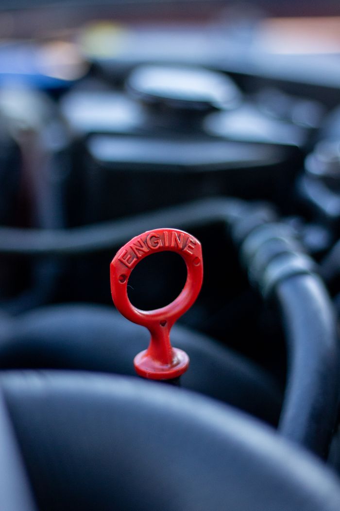 core-values Detailed view of a red engine dipstick in an automobile, emphasizing selective focus and automotive mechanics.
